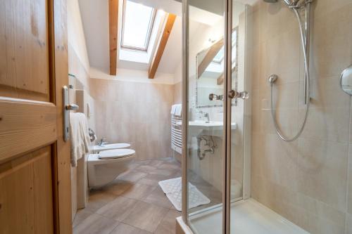 uma casa de banho com um chuveiro e um WC. em Hof Zerund em Castelrotto