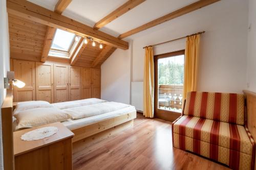 a bedroom with a bed and a window at Hof Zerund in Castelrotto