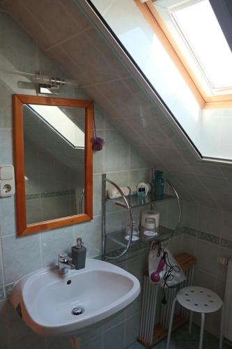 uma casa de banho com um lavatório, um espelho e uma clarabóia em Memory Vendégház em Várvölgy