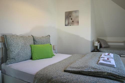 um quarto com uma cama com uma almofada verde em Memory Vendégház em Várvölgy