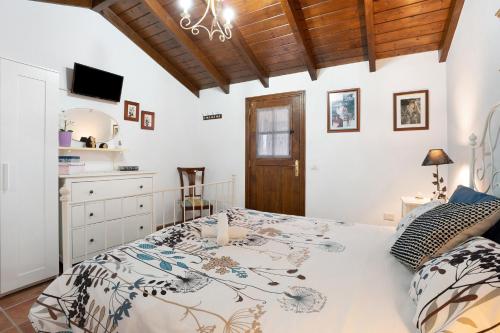 a bedroom with a large bed and a wooden ceiling at Finca Los Angeles in San Juan de la Rambla