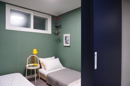 首爾的住宿－Mapo 2bedroom house，一间卧室配有两张床和一张带台灯的桌子