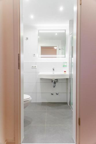 a bathroom with a sink and a toilet at Bodensee-Hotel Kreuz in Uhldingen-Mühlhofen