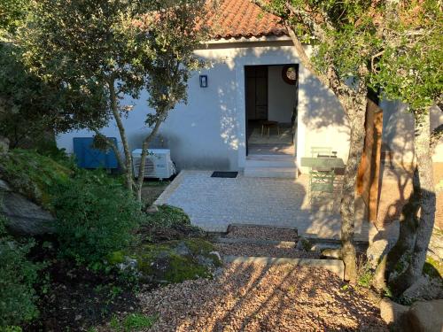 a pathway leading to a white house with trees at studio rocca in Sotta