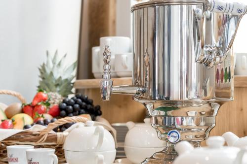 a silver juicer sitting on top of a counter with fruit at Hotel Loy in Gröbming