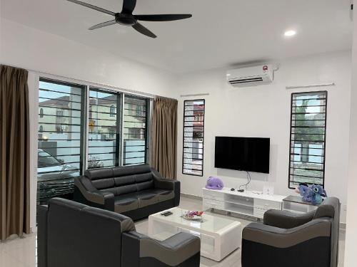 a living room with two chairs and a flat screen tv at 53 Mountainville Semi-D Bungalow-13-18pax in Ipoh