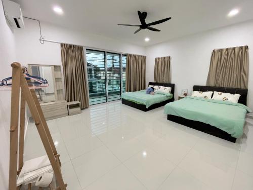 a bedroom with two beds and a ceiling fan at 53 Mountainville Semi-D Bungalow-13-18pax in Ipoh