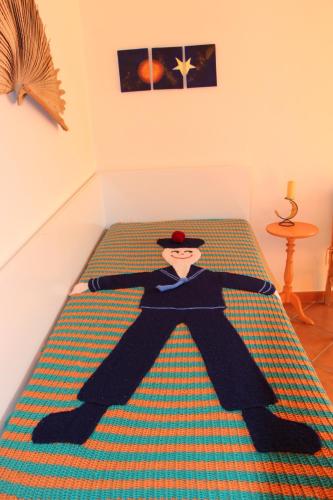 a doll of a man laying on a bed at Baleal, by the sea with swimming pool in Baleal
