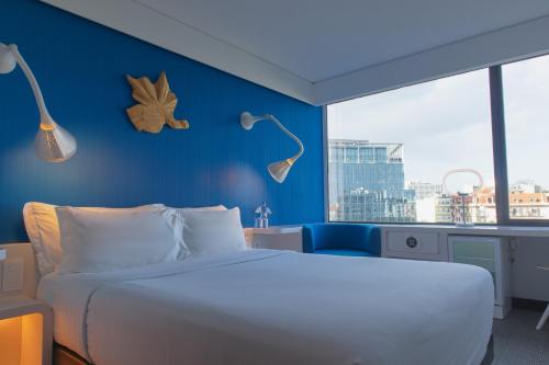 a bedroom with a white bed and a blue wall at EVOLUTION Lisboa Hotel in Lisbon