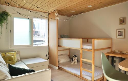 Camera con letti a castello, divano e tavolo di Mapo Rooftop camping house a Seul