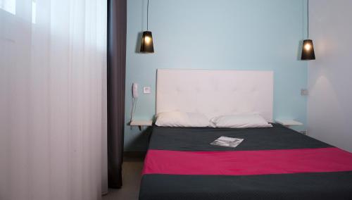 a bedroom with a bed with a red and black blanket at Résidence Coté Mer in La Grande-Motte