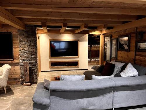 un salon avec un grand canapé et une télévision dans l'établissement Le Paradis de Marie, à Gérardmer