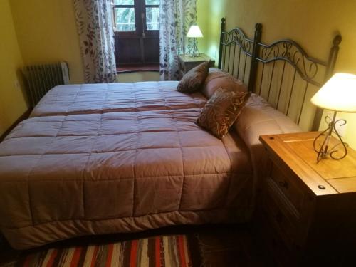 1 cama grande en un dormitorio con mesa de madera en Casa Rural Las Avestruces, en Agulo