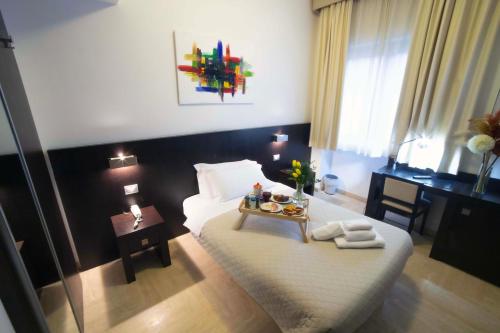 una camera da letto con un letto e un vassoio di cibo sopra di Albergo Cantiani ad Ancona