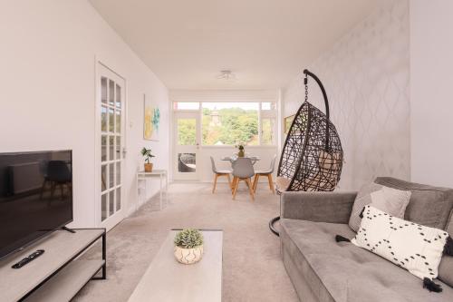 a living room with a couch and a tv at Calton Hill Lookout by Calton Living in Edinburgh