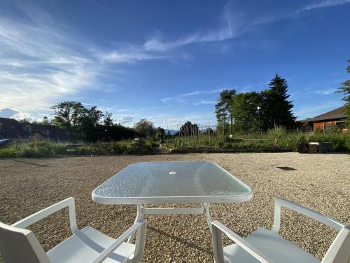 einen Tisch und Stühle auf einem Kieshof in der Unterkunft La Ferme aux Diligences in Neydens
