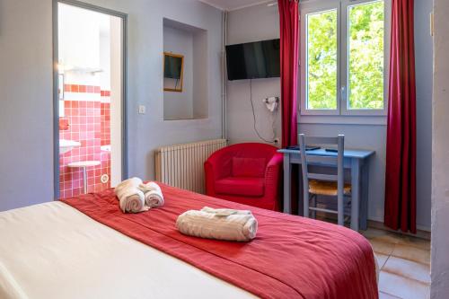 a bedroom with a bed with a red blanket and a red chair at Au Bien Etre piscine in Villecroze