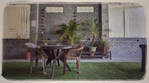 a table and chairs in a room with plants at Shri Ganga View Guest House in Rishīkesh