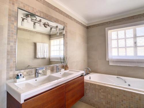 卡尼索Villa Garajau by LovelyStay的一间带大浴缸和大水槽的浴室