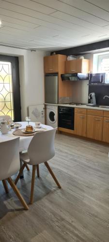 a kitchen with a table and chairs in a room at Au Jardin d'Edel Gîtes Centre Alsace in Dieffenthal