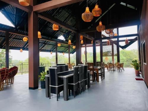 a dining room with tables and chairs and lights at Relax Lake View Resort in Kataragama