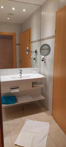 Gesundheits- & Wellness Resort Weissenbach : حمام مع حوض ومرآة
