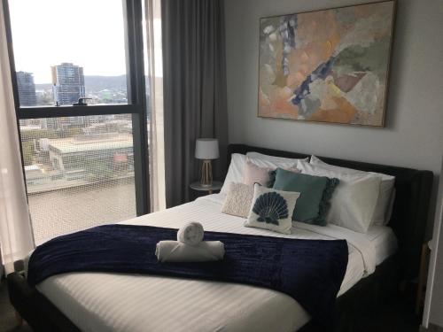 a bedroom with a large bed with a large window at Stylish Stay for Couples in CBD by Stylish Stays in Brisbane