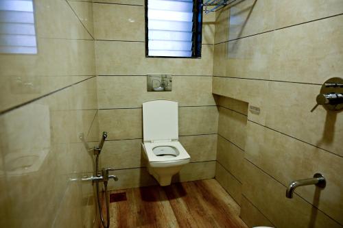 a bathroom with a toilet and a window at Hotel Diamora Residency in Thane