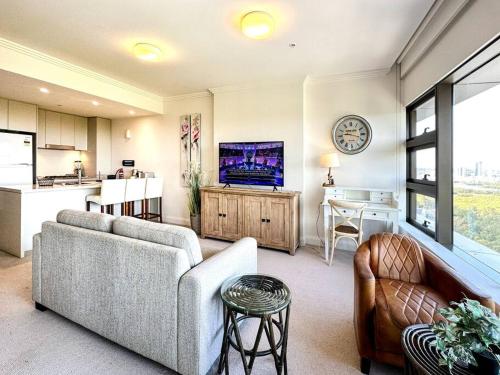 a living room with a couch and a kitchen at Best location apartment in Olympic park in Sydney
