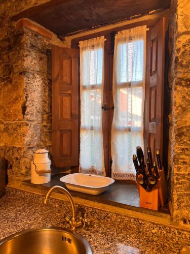 a kitchen counter with a sink and a window at casa rural casa cerezal in Cangas de Onís