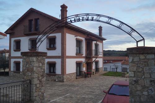 a building with an arch in front of it at Apartamentos Rurales Monfragüe in Torrejón el Rubio