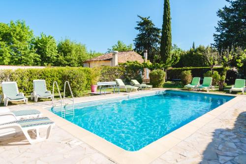 une piscine avec des chaises longues et une maison dans l'établissement Au Bien Etre piscine, à Villecroze