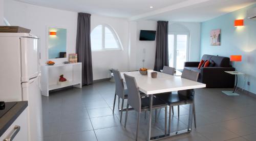 a kitchen and living room with a white table and chairs at Résidence Coté Mer in La Grande-Motte