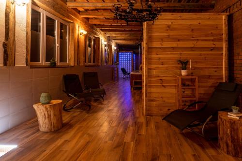 a living room with wooden floors and chairs and a table at Villa Landidyll mit separatem Wellness-Bereich in Joachimsthal