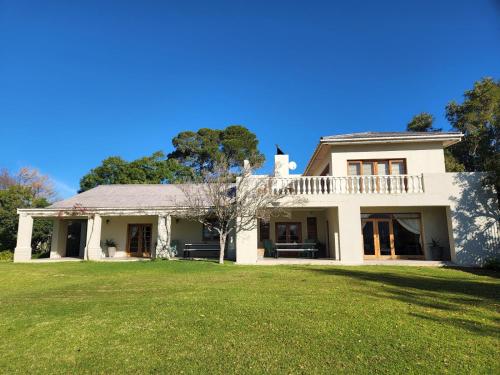 una casa blanca con un gran patio de césped en DuVon Farmhouse, en Robertson