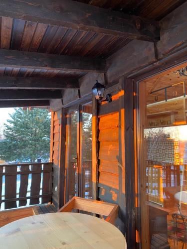 a wooden porch with a table and a window at Ранчо Скарбова Гора in Selisko