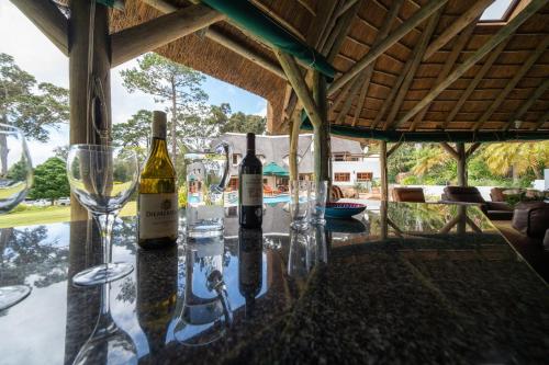 a table with wine bottles and glasses on it at Plotsklaps Self Catering Cottage in Tokai