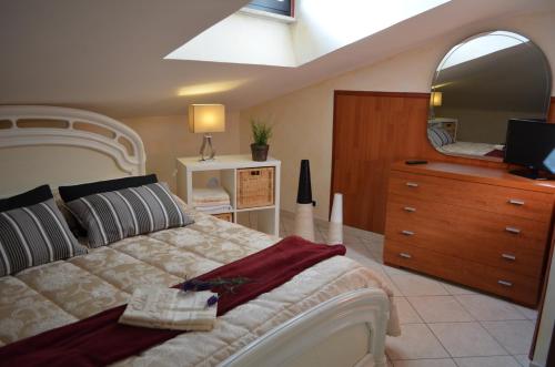 a bedroom with a bed and a dresser and a mirror at Villa Carlini in Passoscuro