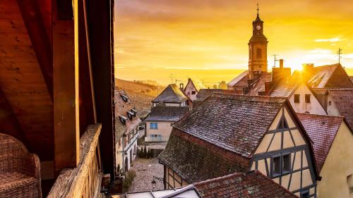 - une vue depuis la fenêtre d'une ville dotée d'une tour d'horloge dans l'établissement Remparts de Riquewihr - La Cigogne Blanche, à Riquewihr