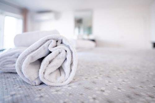 - une serviette blanche sur le lit dans l'établissement La Casa del Maestro Attico, à Pisciotta