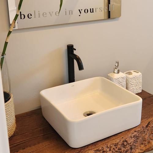 a white sink with a faucet in a bathroom at Casa Arrô - Pousada Boutique in Itajaí