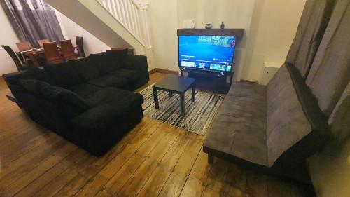 a living room with a couch and a television at Spacious 2 Bedroom Home in Birmingham in Birmingham