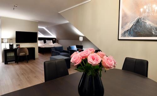 a vase filled with pink roses sitting on a table at Thon Partner Hotel Baronen in Ålesund