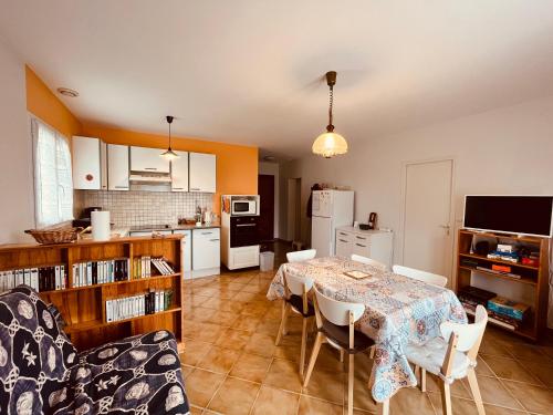 une cuisine et une salle à manger avec une table et des chaises dans l'établissement Maison du Plantin jardin & calme, à Notre-Dame-de-Monts