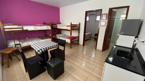 een kamer met paarse muren en een tafel en stoelen bij Cantinho do sossego in Blumenau