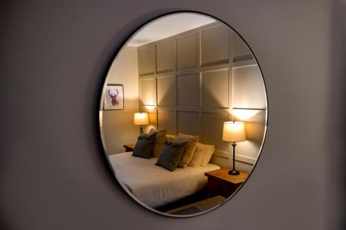 a mirror reflecting a bedroom with a bed and pillows at The Waterfront in Anstruther