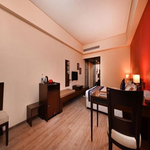 a hotel room with a bed and a desk and a table at The Legend Hotel- Santacruz Near Mumbai International Airport in Mumbai