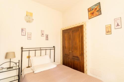 - une chambre avec un lit et une porte en bois dans l'établissement Agriturismo Il Giglio, à Oristano