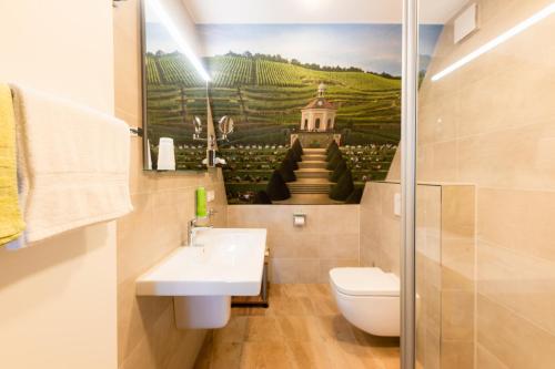 a bathroom with a sink and a toilet and a painting at Berghotel Talblick in Holzhau