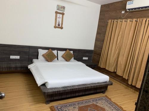 ein Schlafzimmer mit einem Bett in einem Zimmer in der Unterkunft Ruturaj Inn Alibag in Alibag